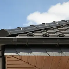 Czarne dachówki do krycia kalenic tworzą estetyczne wykończenie dachu.
