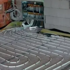 Instalacja ogrzewania podłogowego. Zastanawiasz się, ile za metr podłogówki? Tutaj widać rurki ułożone na siatce, gotowe do zalania.