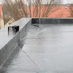 Mokry dach płaski pokryty membraną EPDM, która chroni przed wodą. Widać kratkę odpływową.