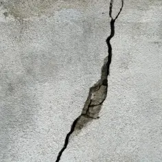 Pęknięty beton na zewnątrz. Zastanawiasz się, czym wyrównać beton na zewnątrz? Ta ściana potrzebuje naprawy.