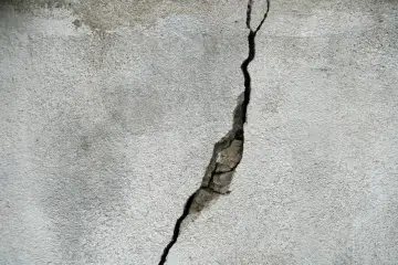 Pęknięty beton na zewnątrz. Zastanawiasz się, czym wyrównać beton na zewnątrz? Ta ściana potrzebuje naprawy.